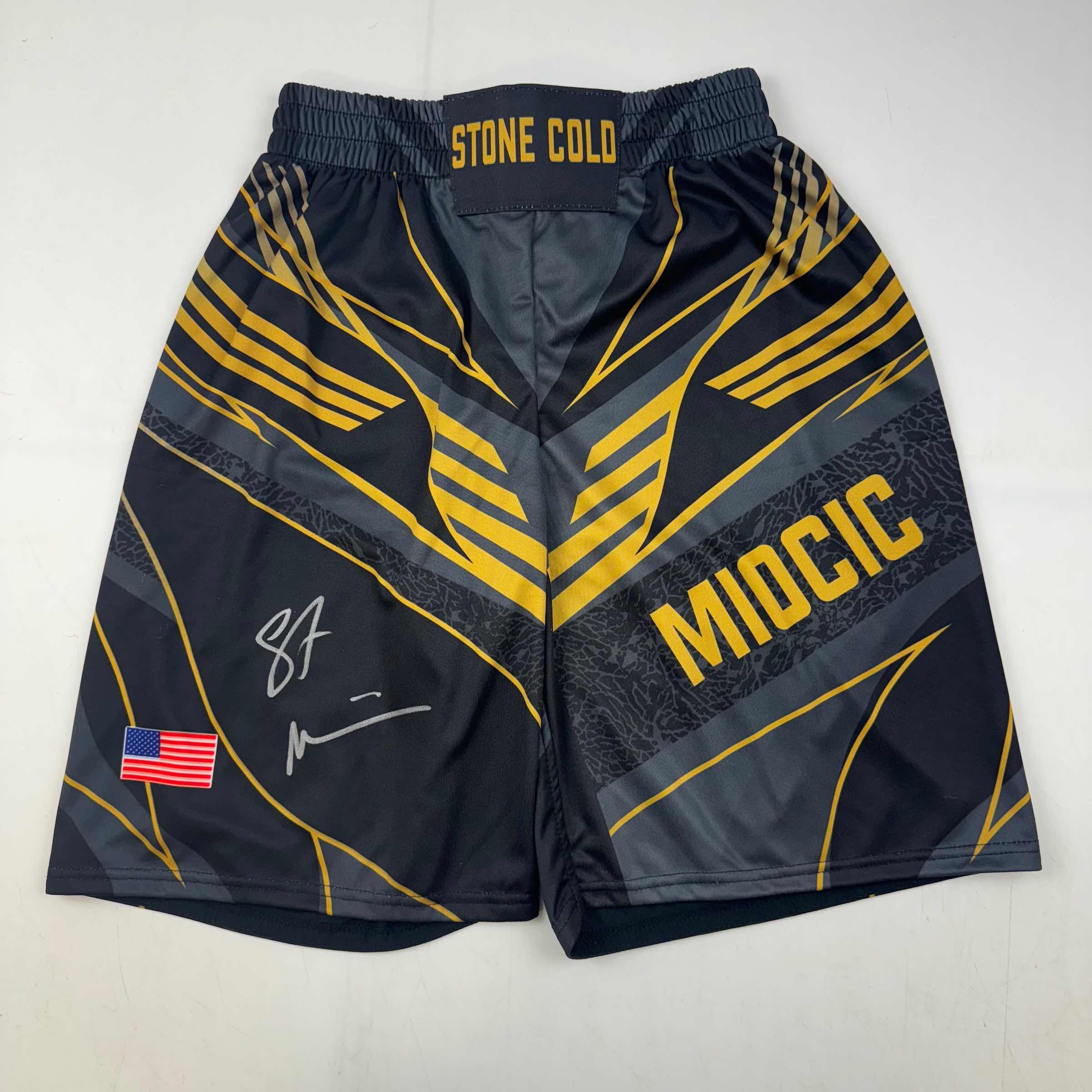 autographed-signed-stipe-miocic-black-and-gold-ufc-mma-trunks-shorts-ultimate-fighting-beckett-bas-coa