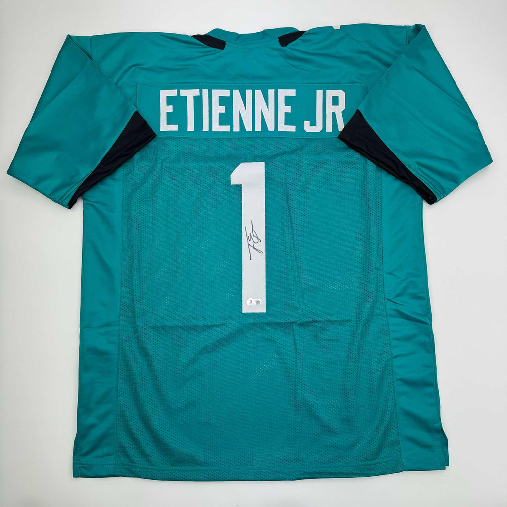 autographed-signed-travis-etienne-jr-jacksonville-teal-football-jersey-beckett-bas-coa
