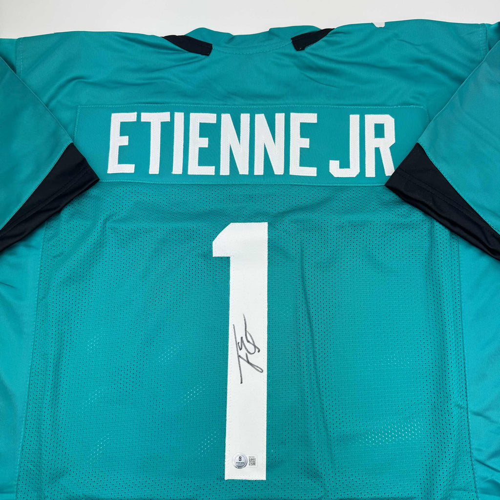 autographed-signed-travis-etienne-jr-jacksonville-teal-football-jersey-beckett-bas-coa