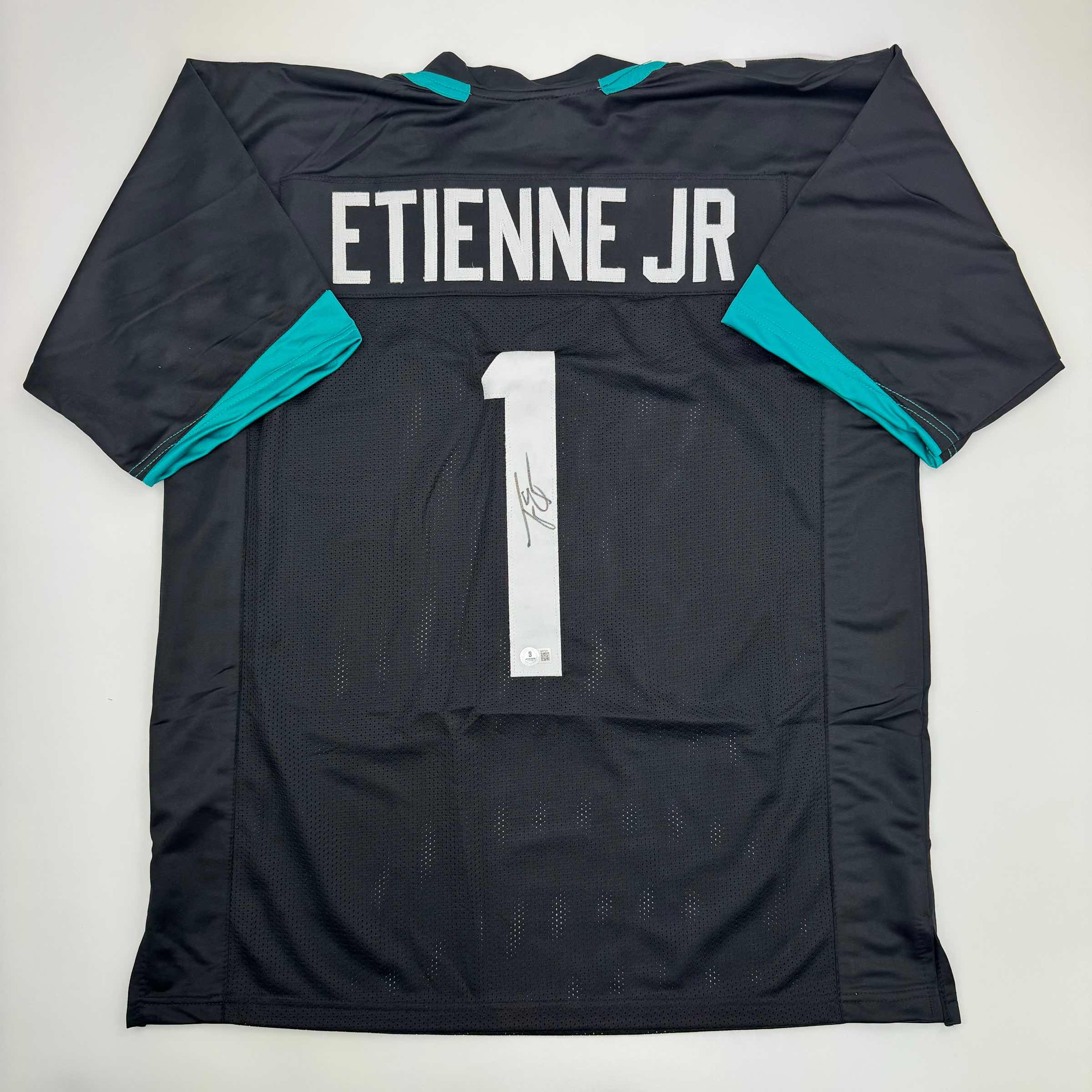autographed-signed-travis-etienne-jr-jacksonville-black-football-jersey-beckett-bas-coa